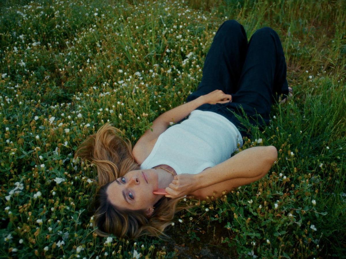 Femme allongée dans l'herbe se massant avec guasha